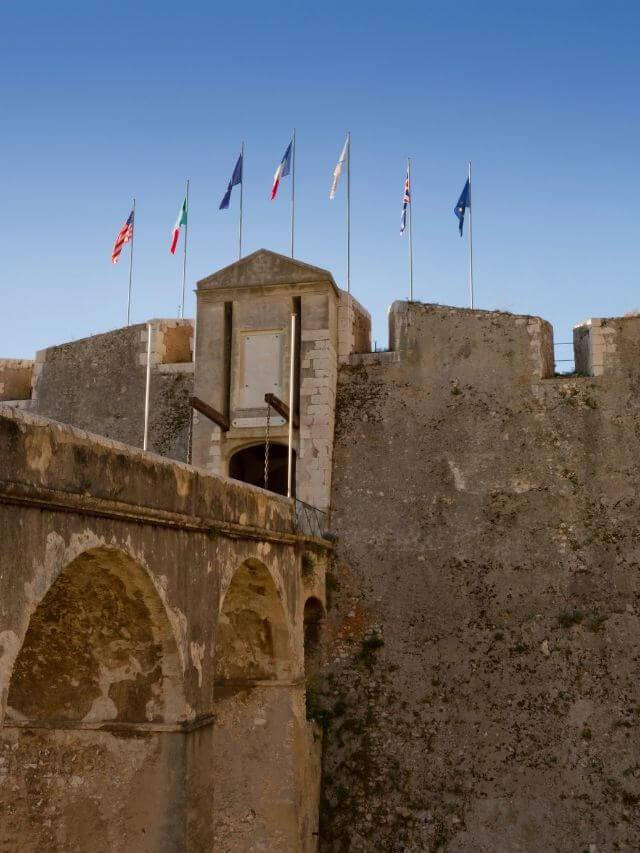 Port Fort du Mont Alban con banderas de países y cielo azul