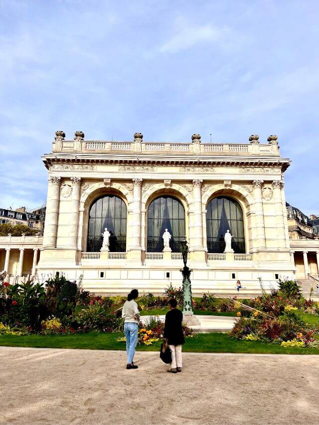 Gente delante del edificio blanco del Palais Galliera, uno de los mejores museos de moda de París