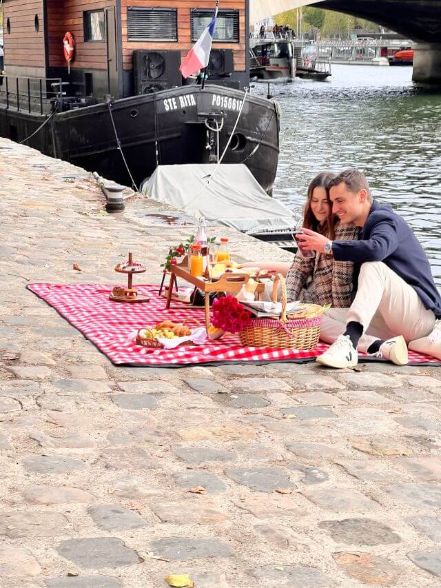 Couple picnicking on the banks of the Seine
