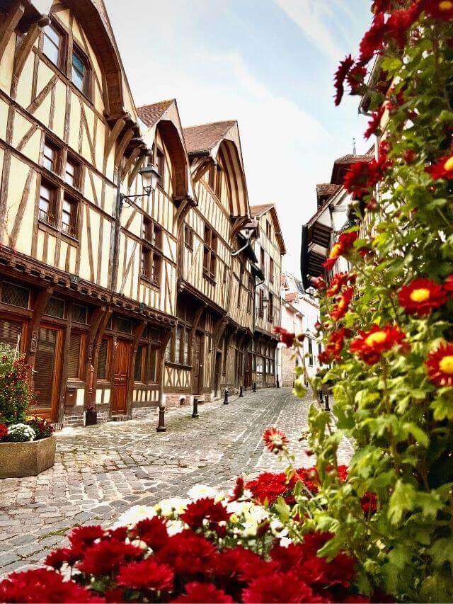 Troyes casas de madera y flores rojas