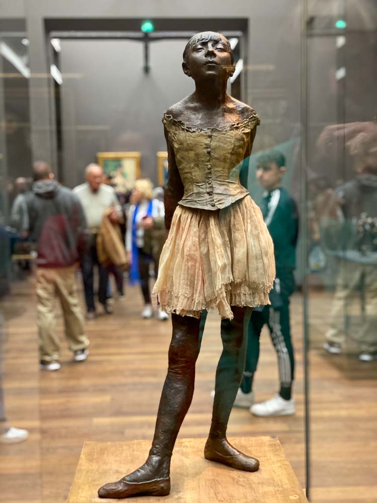 Una chica con vestido esculpe en París en octubre