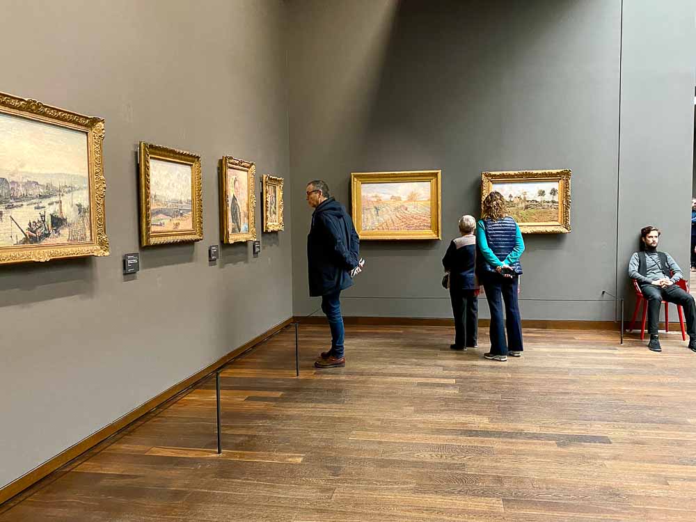 Gente mirando cuadros en el Museo de Orsay durante el mes de octubre en París