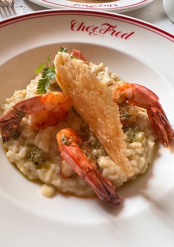 formule in Chez Fred with prawns on top of a risotto while traveling to France on a budget