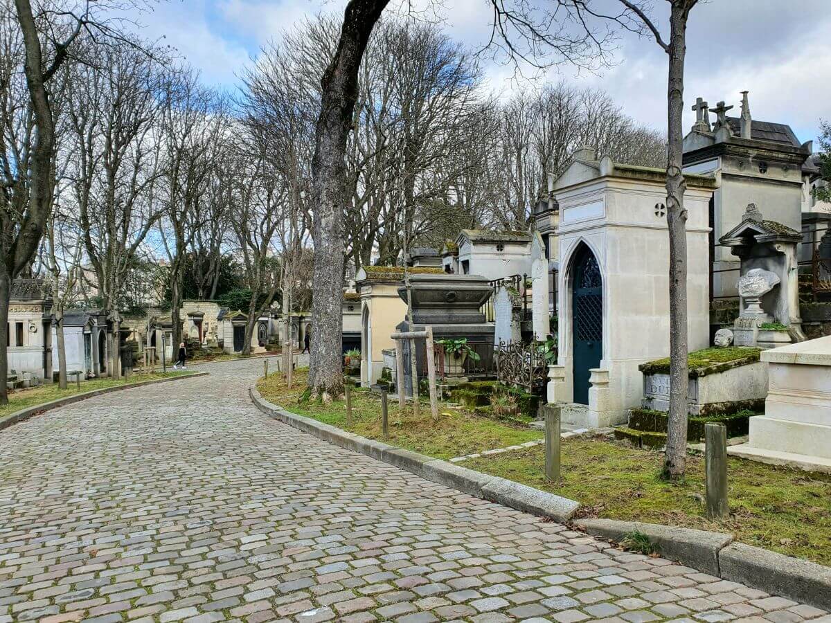A path to the Pere Lachaise Cemetery with the tombs on the side during Paris in September