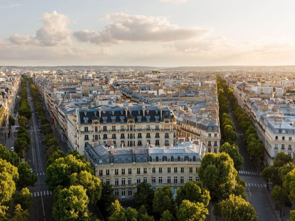 aerial view of the 16th arrondissement with white buildings forming streets with trees under an afternoon sky