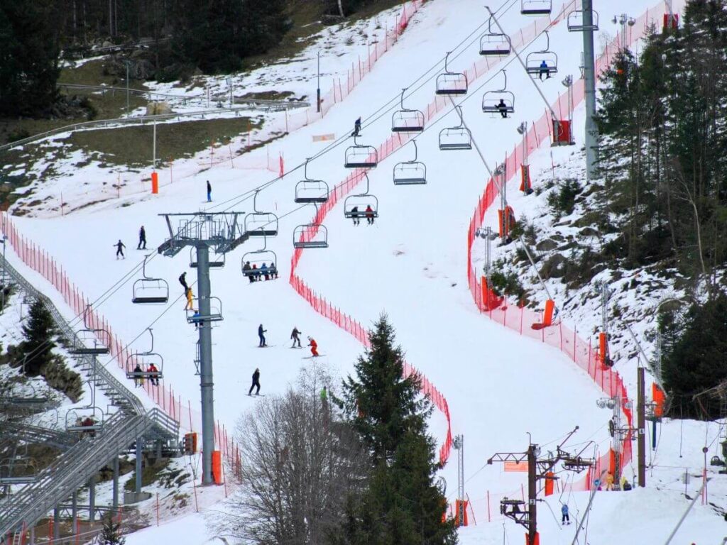 Trail for skiing with people riding the ski lifts in winter in France in the Chamonix slopes