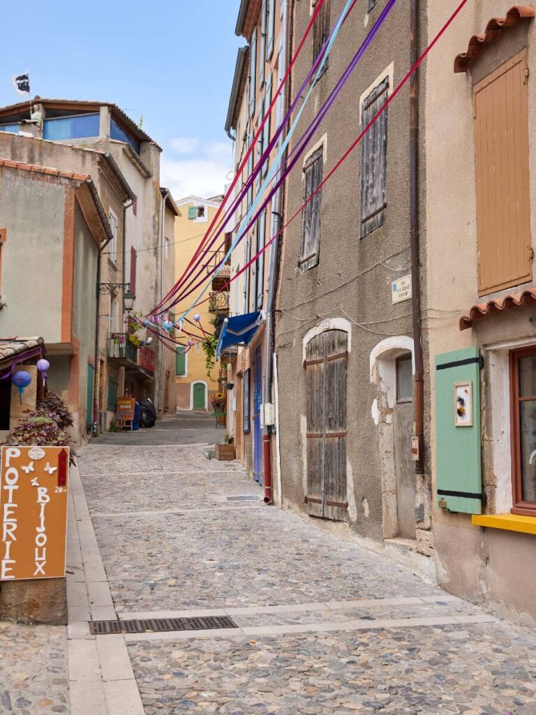 Una calle de valensole provence con un letrero de una tienda de cerámica