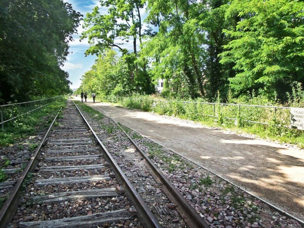 Vías de tren en PETITE CEINTURE en París en octubre con gente caminando durante un recorrido