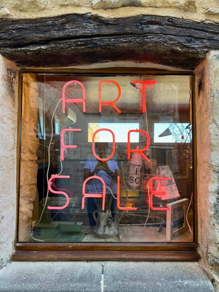 Cartel art for sale en la ventana de una galería de arte