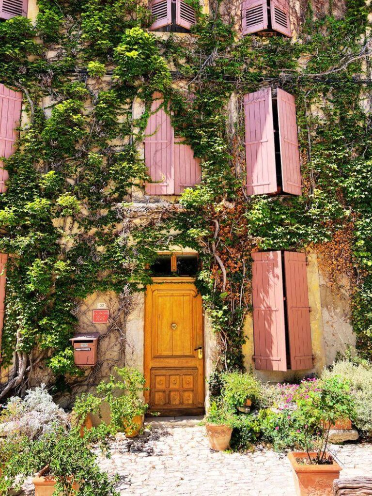 Preciosa casa en Saignon con hojas verdes y ventanas rosas