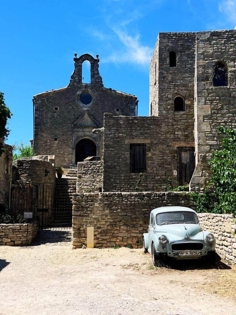 Antigua iglesia rupestre con un coche clásico azul claro